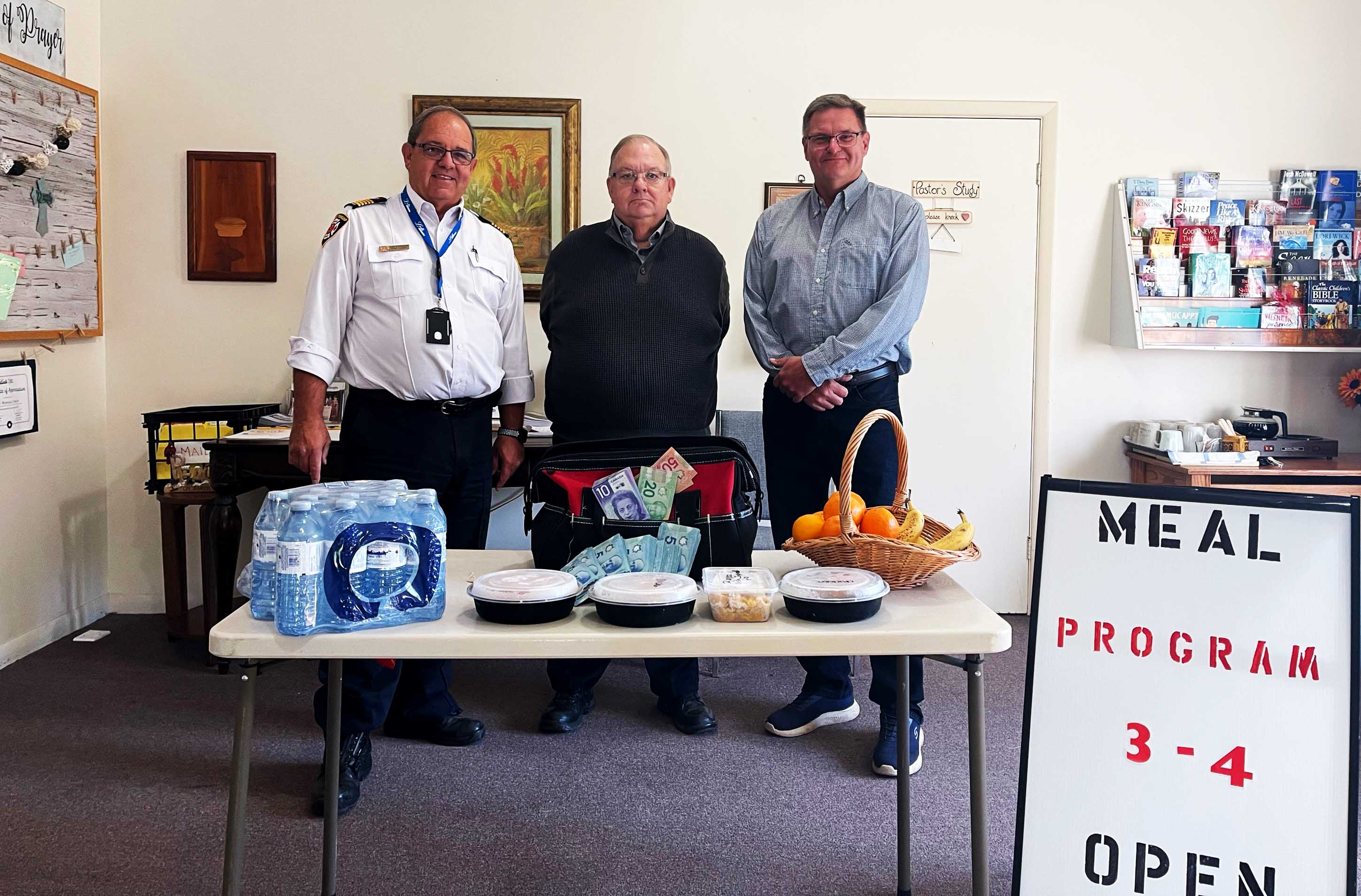 Mayor and Fire Chief presenting a donation to Pastor Ross of Odessa Free Methodist Church