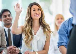 woman raising her hand to ask a question