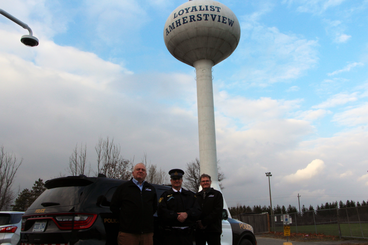 Left to right: Councillor Paul Proderick, Detachment Commander John Hatch and Mayor Jim Hegadorn standing in front of the Amherstview water tower located next to the Leisure & Activity Centre where facility security cameras have recently been registered as part of the CAMSafe program in Loyalist Township.