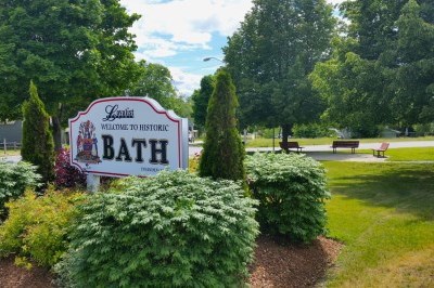 welcome to Bath sign in a flowerbed with grass and trees