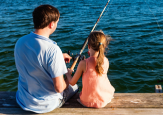 father and daughter fishing off dock