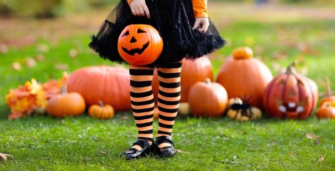 girl in costume with pumpkins