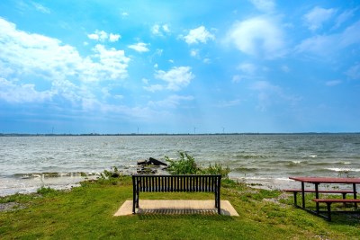 bench at lake edge looking at Amherst Island