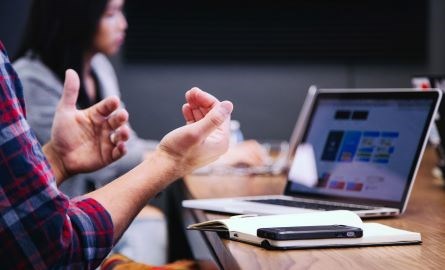 people in a meeting with a laptop and cellphone