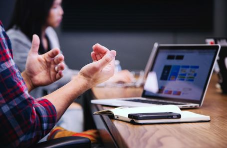 people in a meeting with a laptop and cellphone