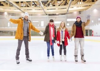 four adults skating at a rink