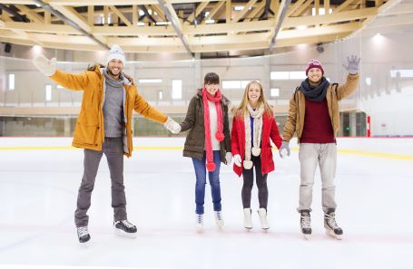 four adults skating at a rink
