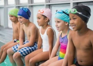 children sitting on the edge of a swimming pool