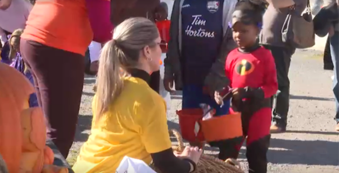 Woman giving small child candy for halloween