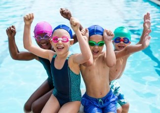 children with their arms up in the pool