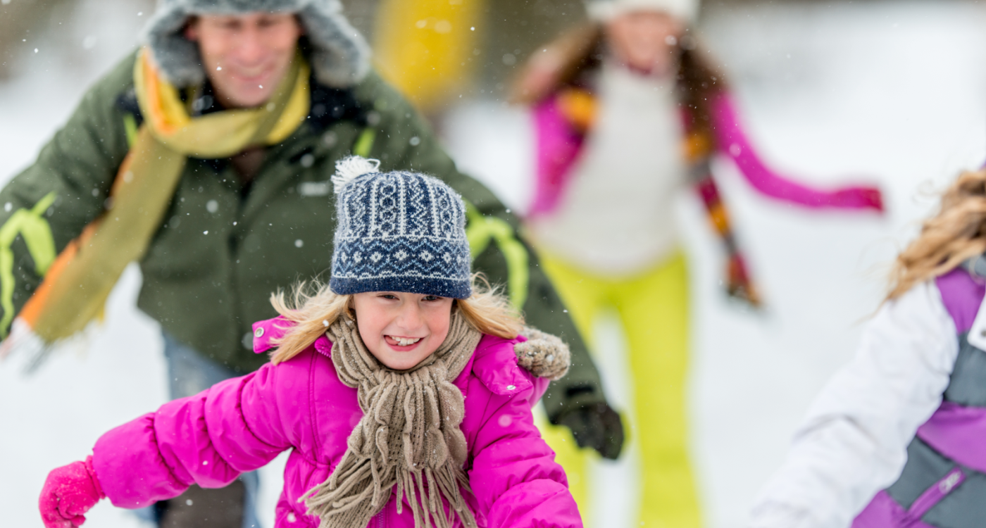 little girl ice skating in a group outdoors