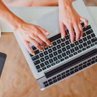 Hands typing on laptop keyboard