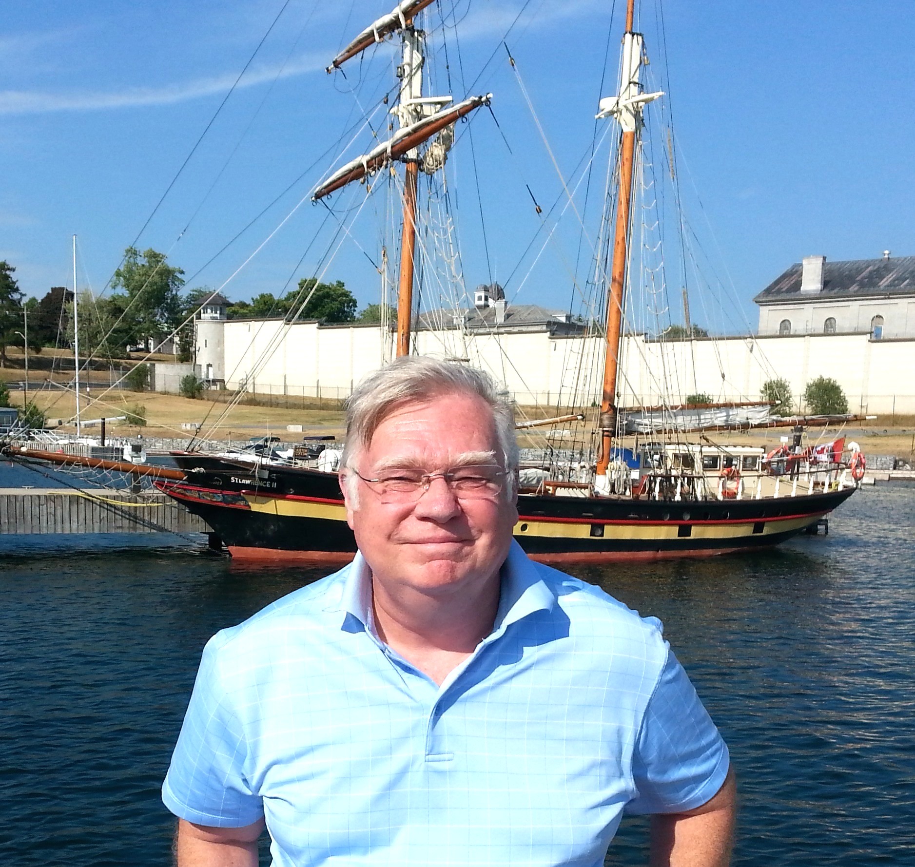 Man standing in front of old sailing boat