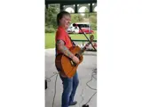 Person singing and playing guitar.