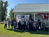 Students with Amherst Island residents in front of a white building.