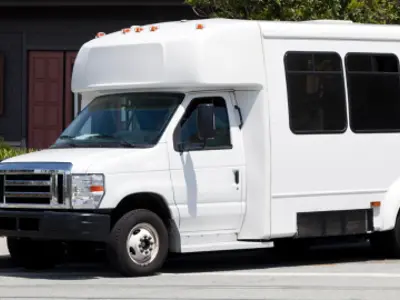 Small transit bus parked in front of building