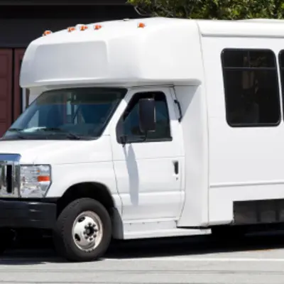 Small transit bus parked in front of building