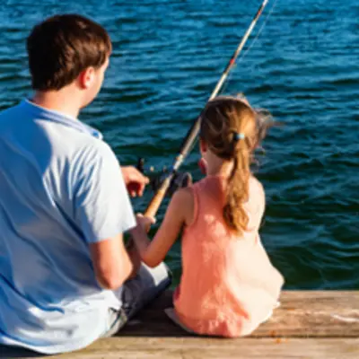 father and daughter fishing off dock
