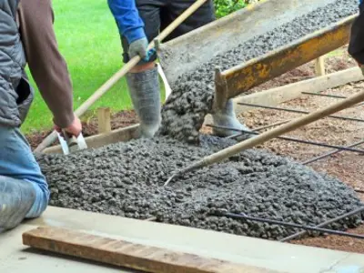 workers pouring concrete to form a driveway