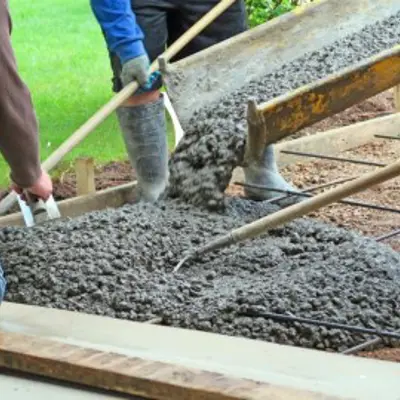 workers pouring concrete to form a driveway