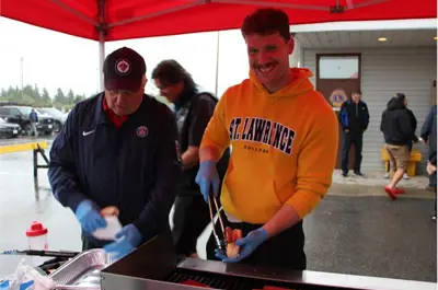 Man cooking and serving hotdog
