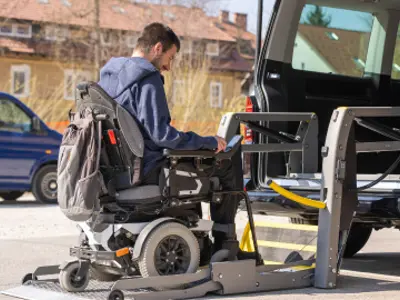 Man in wheelchair getting on ramp for accessible van