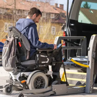 Man in wheelchair getting on ramp for accessible van