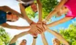 people linking hands in a circle