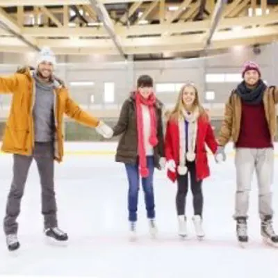 four adults skating at a rink
