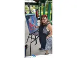 A lady painting a picture of a performer.
