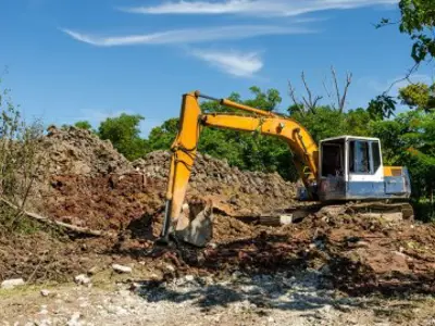 backhoe next to a large pile of sod