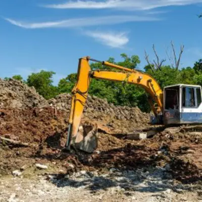 backhoe next to a large pile of sod